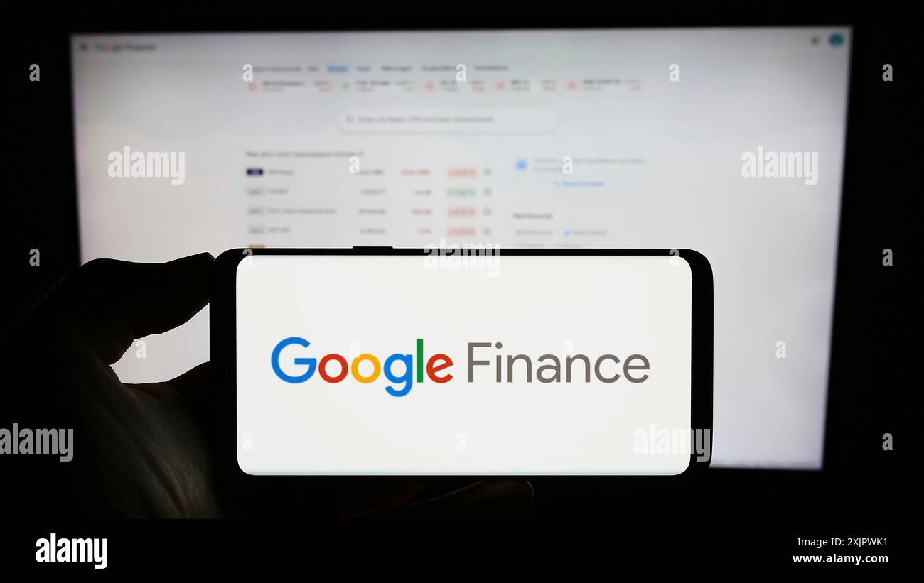 Stuttgart, Allemagne, 09-23-2023 : personne tenant un téléphone portable avec le logo de la plate-forme d'information financière Google Finance sur l'écran en face de la page Web. Banque D'Images