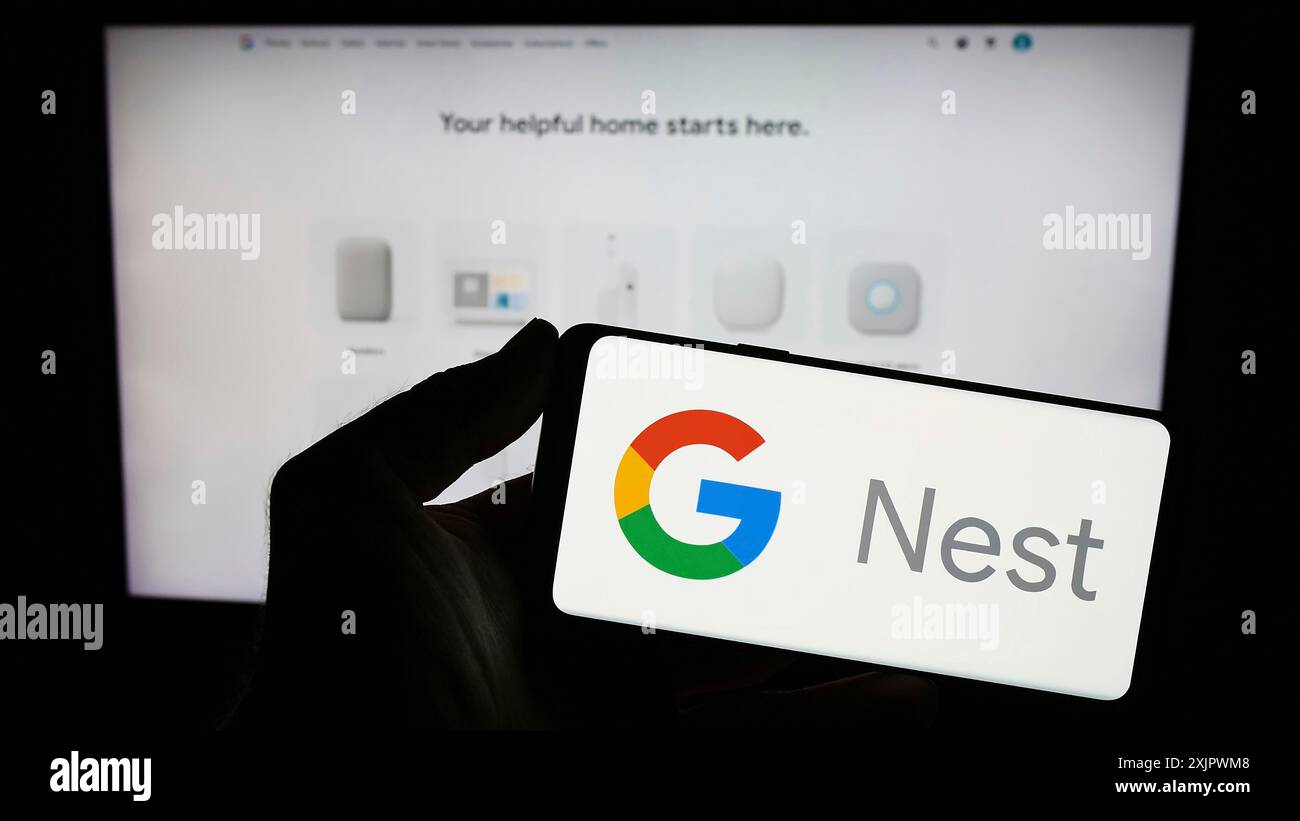 Stuttgart, Allemagne, 09-23-2023 : personne tenant un smartphone avec le logo de la plate-forme de maison intelligente Google Nest sur l'écran devant le site Web. Concentrez-vous sur le téléphone Banque D'Images