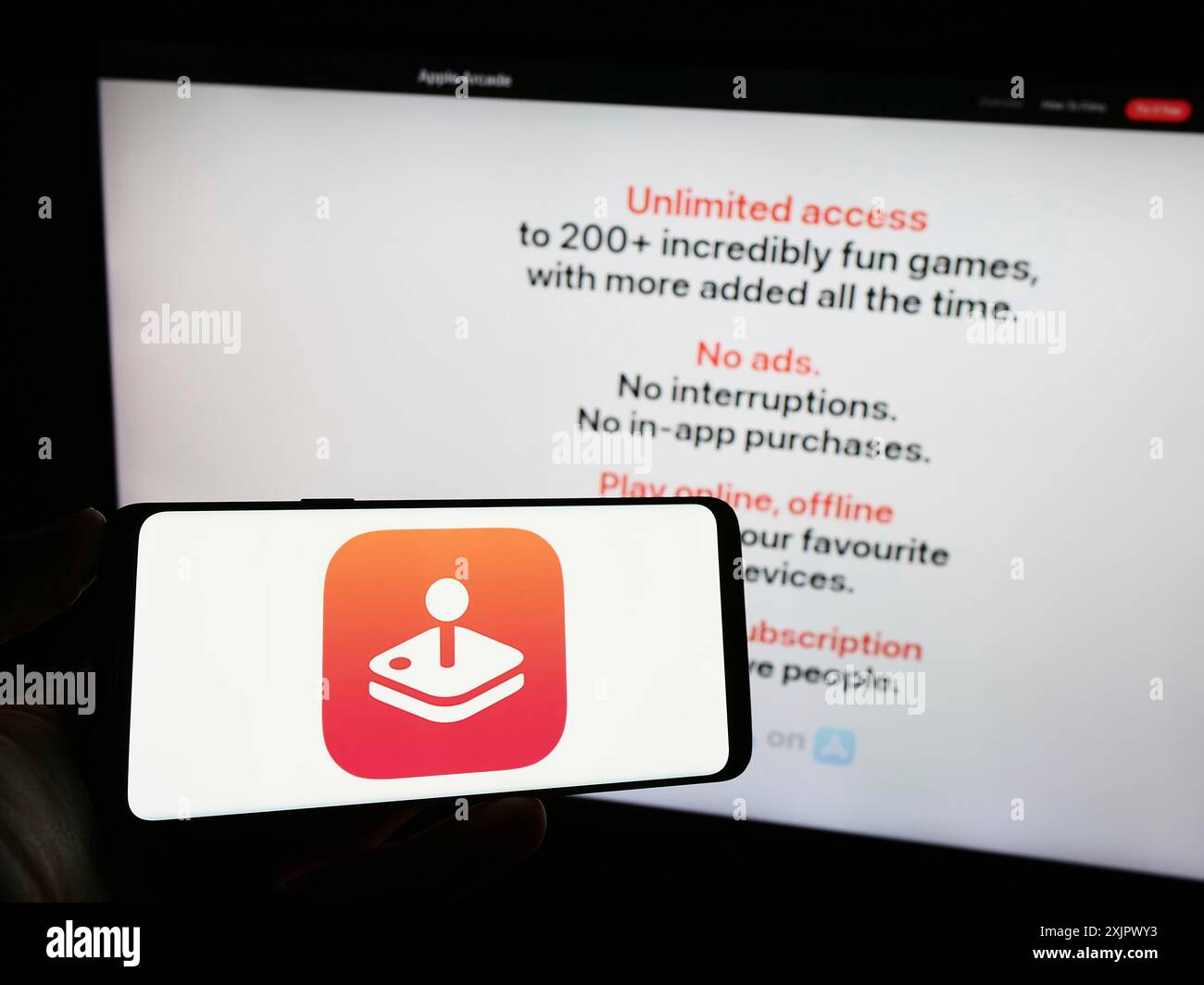 Stuttgart, Allemagne, 09-23-2023 : personne tenant le téléphone portable avec le logo de la plate-forme de jeu vidéo Apple Arcade sur l'écran en face de la page Web de l'entreprise. Banque D'Images