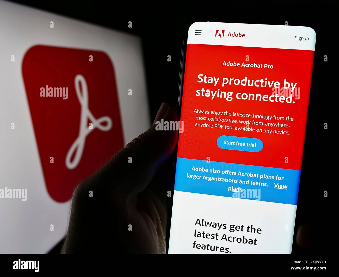Stuttgart, Allemagne, 09-23-2023 : personne tenant un smartphone avec la page web du logiciel de gestion PDF Adobe Acrobat sur l'écran devant le logo. Concentrez-vous sur Banque D'Images