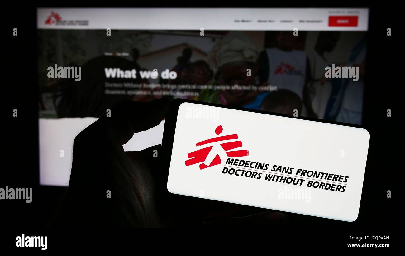 Stuttgart, Allemagne, 10-06-2023 : personne tenant un téléphone portable avec le logo de l'organisation caritative Doctors Without Borders devant la page web. Concentrez-vous sur Banque D'Images