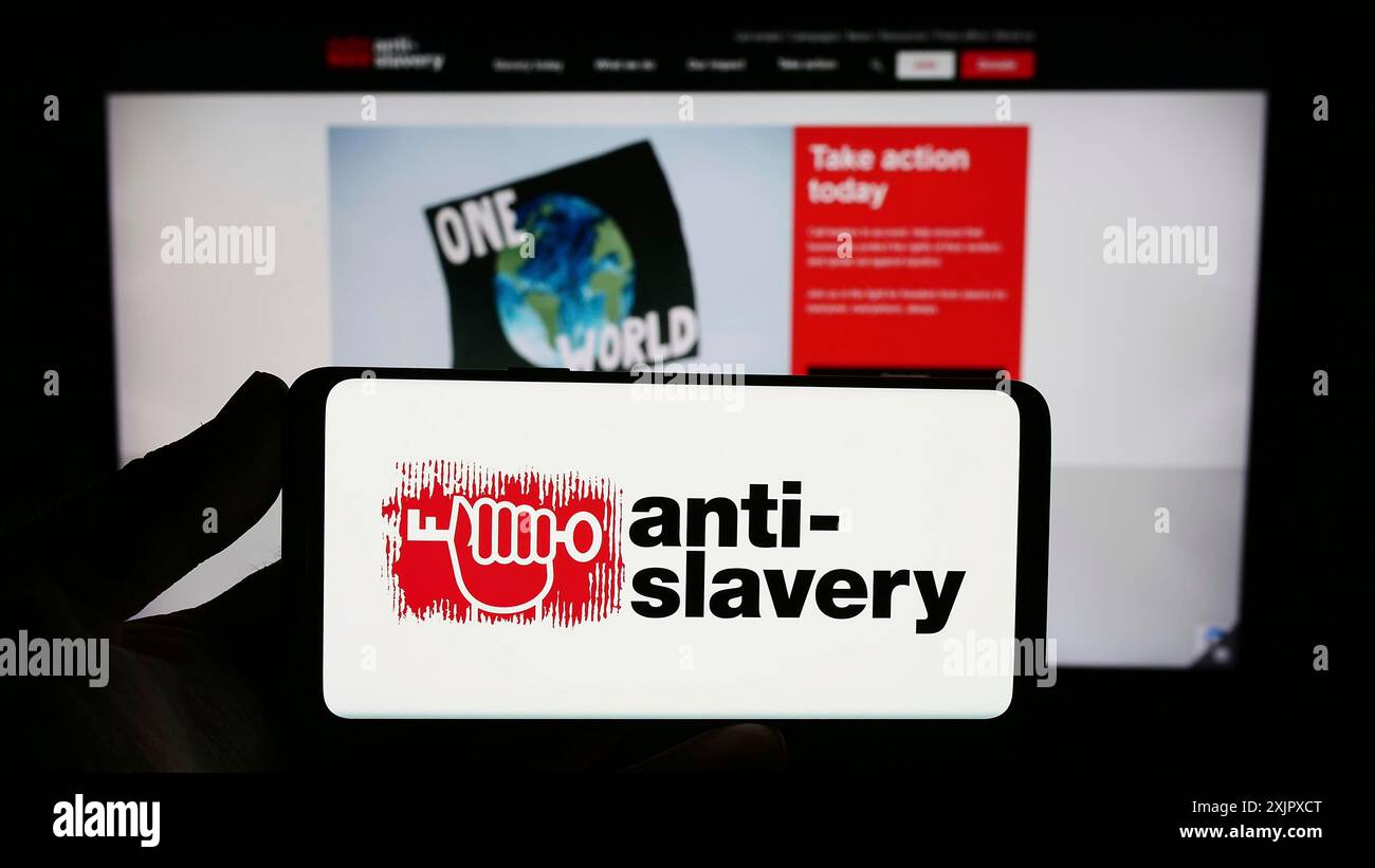Stuttgart, Allemagne, 10-09-2023 : personne tenant un smartphone avec le logo de l'organisation britannique anti-Slavery International devant le site web. Concentrez-vous sur Banque D'Images