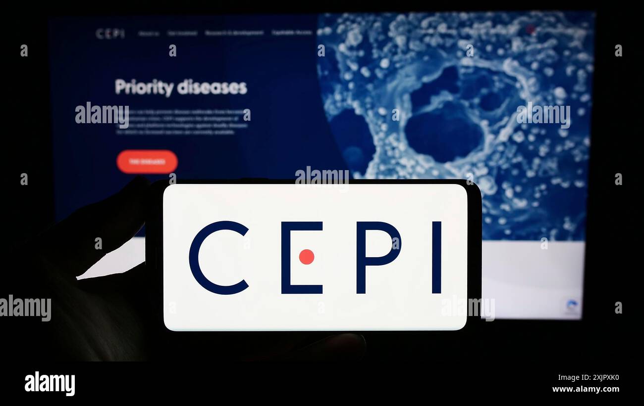 Stuttgart, Allemagne, 10-11-2023 : personne tenant un smartphone avec le logo de la Coalition for Epidemic Preparedness innovations (CEPI) devant le site web. Banque D'Images