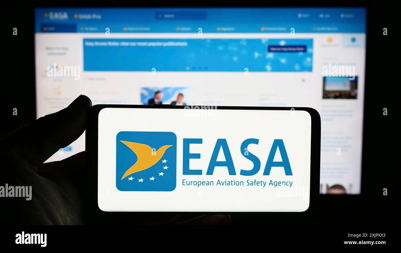 Stuttgart, Allemagne, 10-17-2023 : personne tenant un smartphone avec le logo de l'Agence de la sécurité aérienne de l'Union européenne (AESA) devant le site web. Concentrez-vous sur Banque D'Images