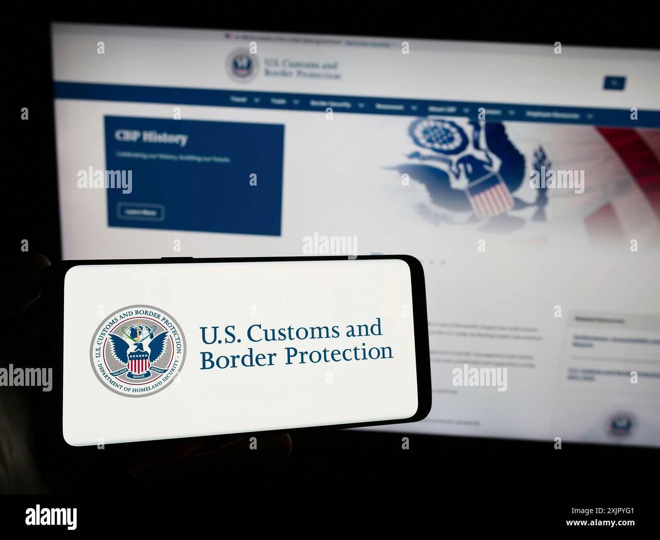 Stuttgart, Allemagne, 10 29 2023 : personne tenant un smartphone avec le sceau de l'agence United States Customs and Border protection (CBP) devant le site Web. Banque D'Images