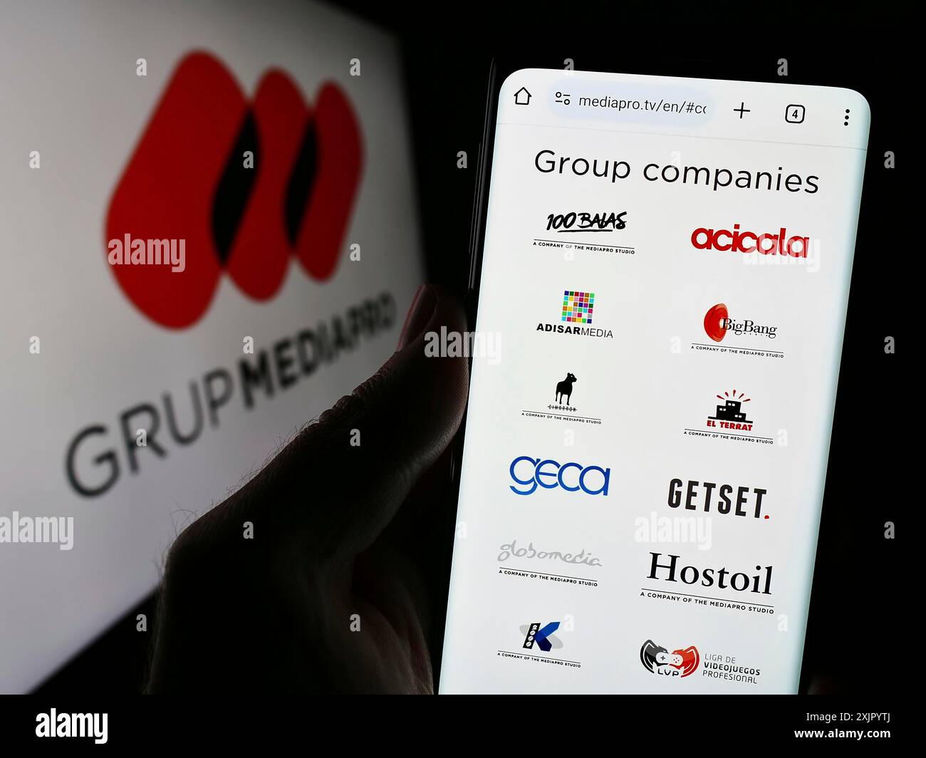 Stuttgart, Allemagne, 10 31 2023 : personne tenant un téléphone portable avec le site Web de la société multimédia espagnole Mediapro Group devant le logo. Concentrez-vous sur Banque D'Images