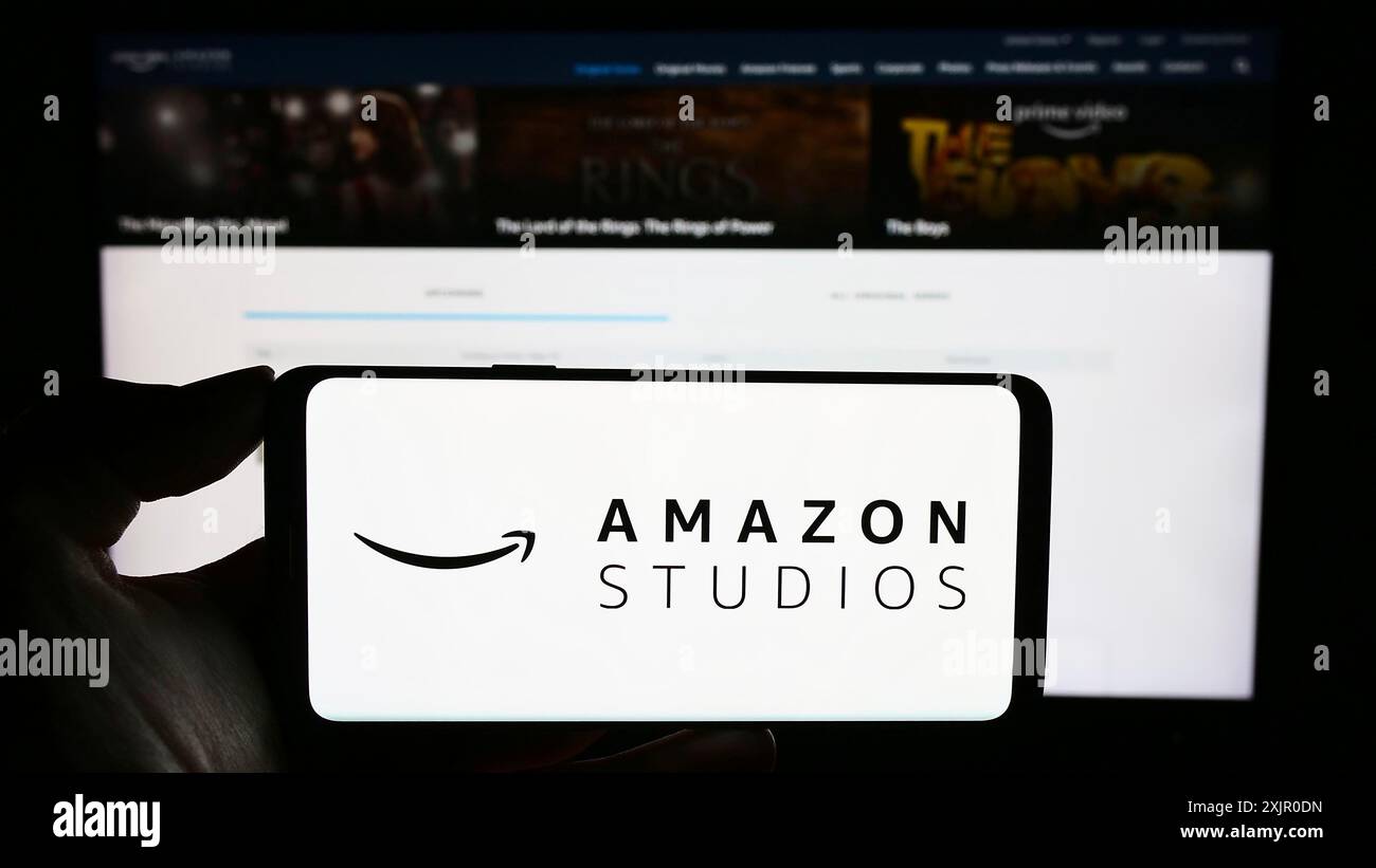 Stuttgart, Allemagne, 11-08-2023 : personne tenant un téléphone portable avec le logo de la société américaine de production cinématographique et télévisuelle Amazon Studios devant Banque D'Images