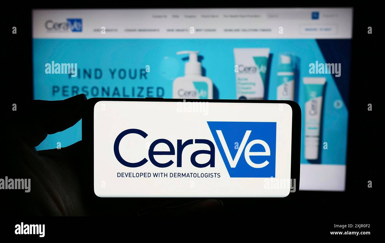 Stuttgart, Allemagne, 11-08-2023 : personne tenant un smartphone avec le logo de la société de soins personnels CeraVe (l? Oréal) devant le site Web. Concentrez-vous sur le téléphone Banque D'Images
