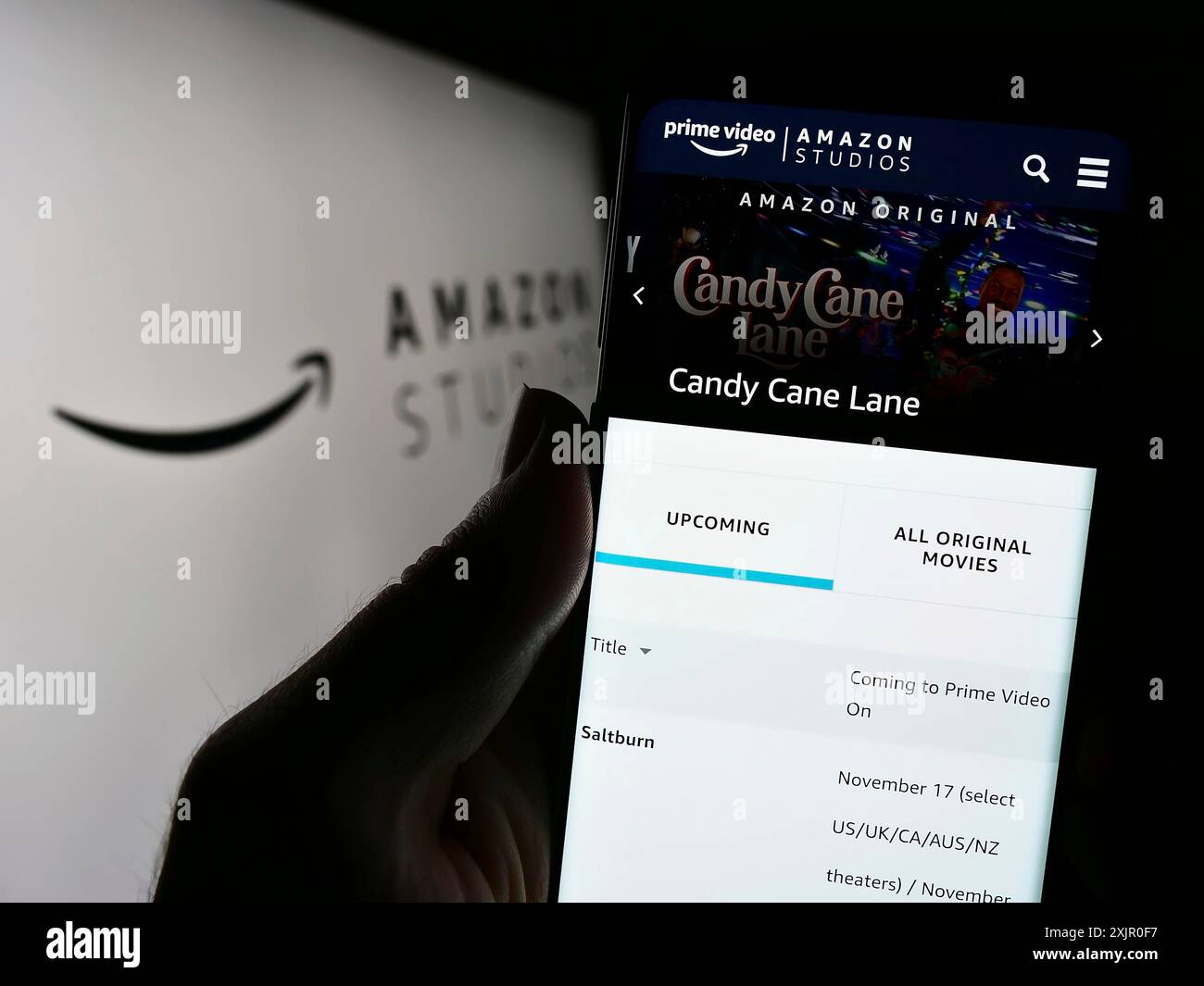 Stuttgart, Allemagne, 11-08-2023 : personne tenant un smartphone avec la page web de la société américaine de production cinématographique et télévisuelle Amazon Studios avec le logo. Mise au point Banque D'Images