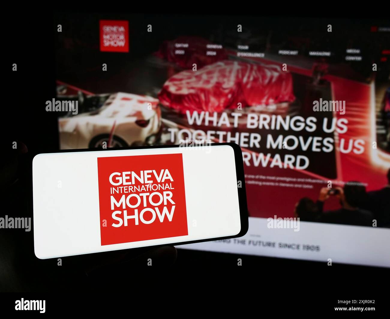 Stuttgart, Allemagne, 11-10-2023 : personne tenant un smartphone avec le logo du salon suisse de l'auto de Genève International Motor Show en face du site. Concentrez-vous sur Banque D'Images