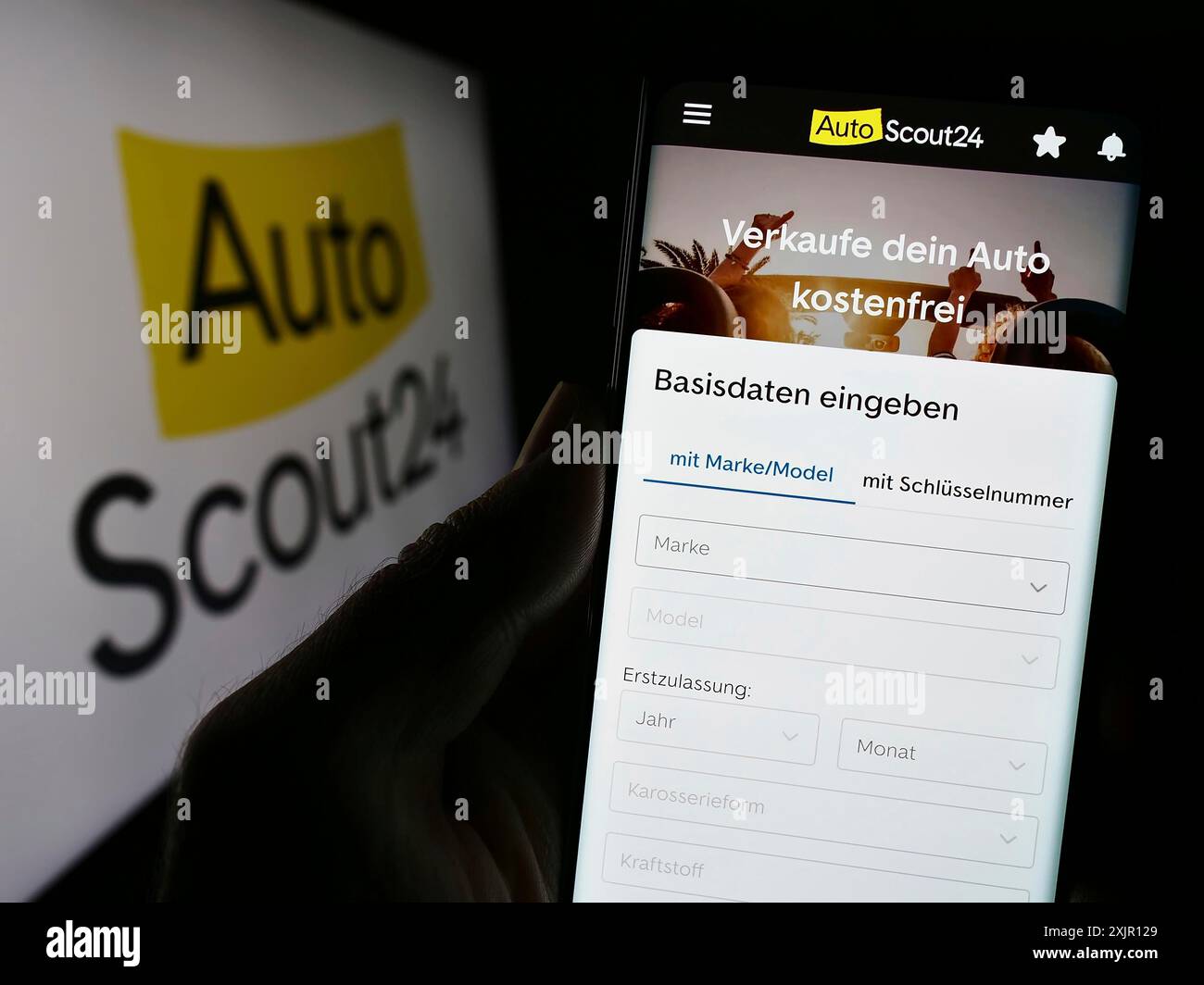 Stuttgart, Allemagne, 11-14-2023 : personne tenant le téléphone portable avec la page Web de la société allemande de marché en ligne de voiture AutoScout24 GmbH avec le logo. Concentrez-vous sur Banque D'Images