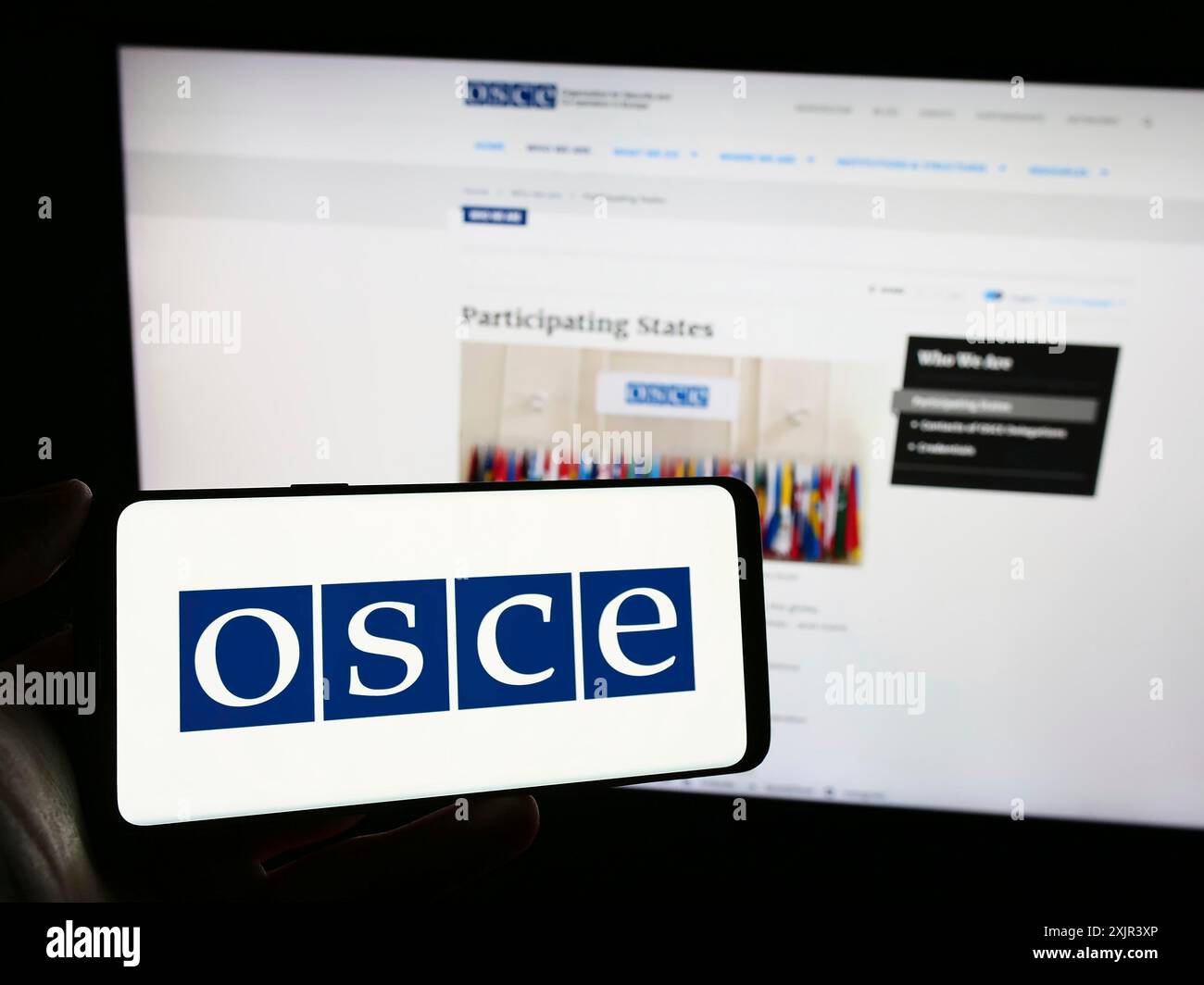 Stuttgart, Allemagne, 12-28-2023. Personne tenant un téléphone portable avec le logo de l'Organisation pour la sécurité et la coopération en Europe (OSCE) devant Banque D'Images