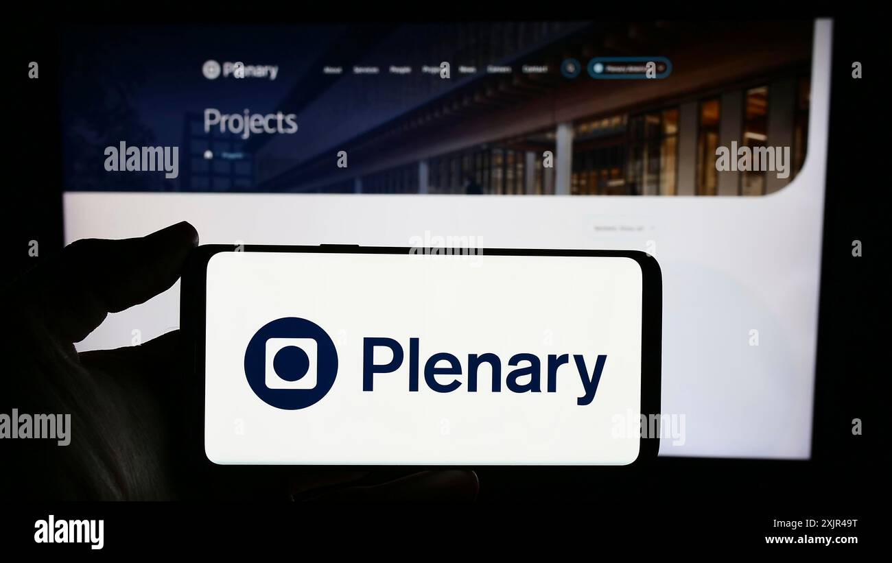 Stuttgart, Allemagne, 02-07-2023 : personne tenant un téléphone portable avec le logo de la société australienne d'investissement dans les infrastructures Plenary Group en face de la page Web. Banque D'Images