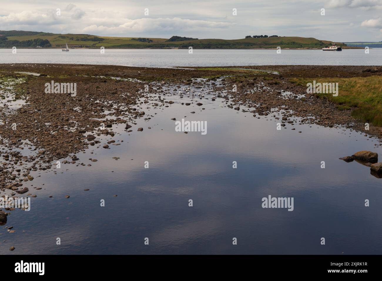 Une vue depuis la ville balnéaire de Largs, montrant la côte écossaise, où un ferry fait son chemin vers l'île de Cumbrae, Banque D'Images