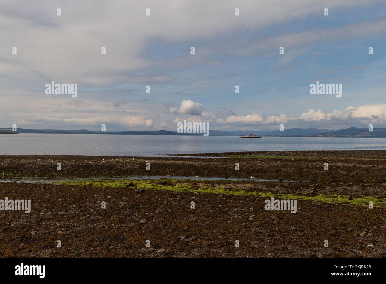 Une vue depuis la ville balnéaire de Largs, montrant la côte écossaise, où un ferry fait son chemin vers l'île de Cumbrae, Banque D'Images