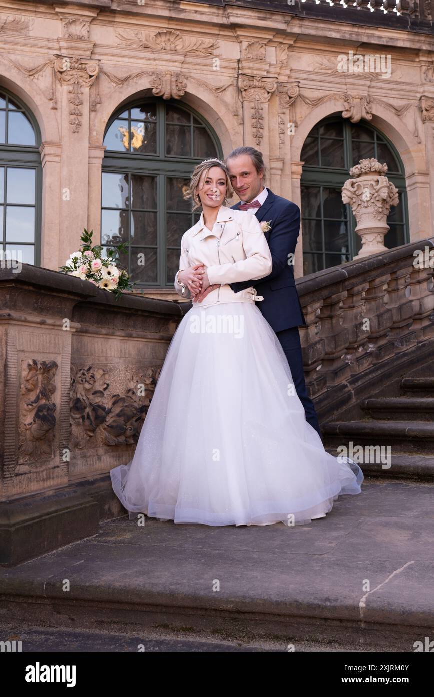 Beau couple, jeunes mariés en promenade. Mariée et mariée sont debout sur les marches du palais. Famille Banque D'Images Beau couple, jeunes mariés en promenade. Mariée et mariée sont debout sur les marches du palais. Famille Banque D'Images