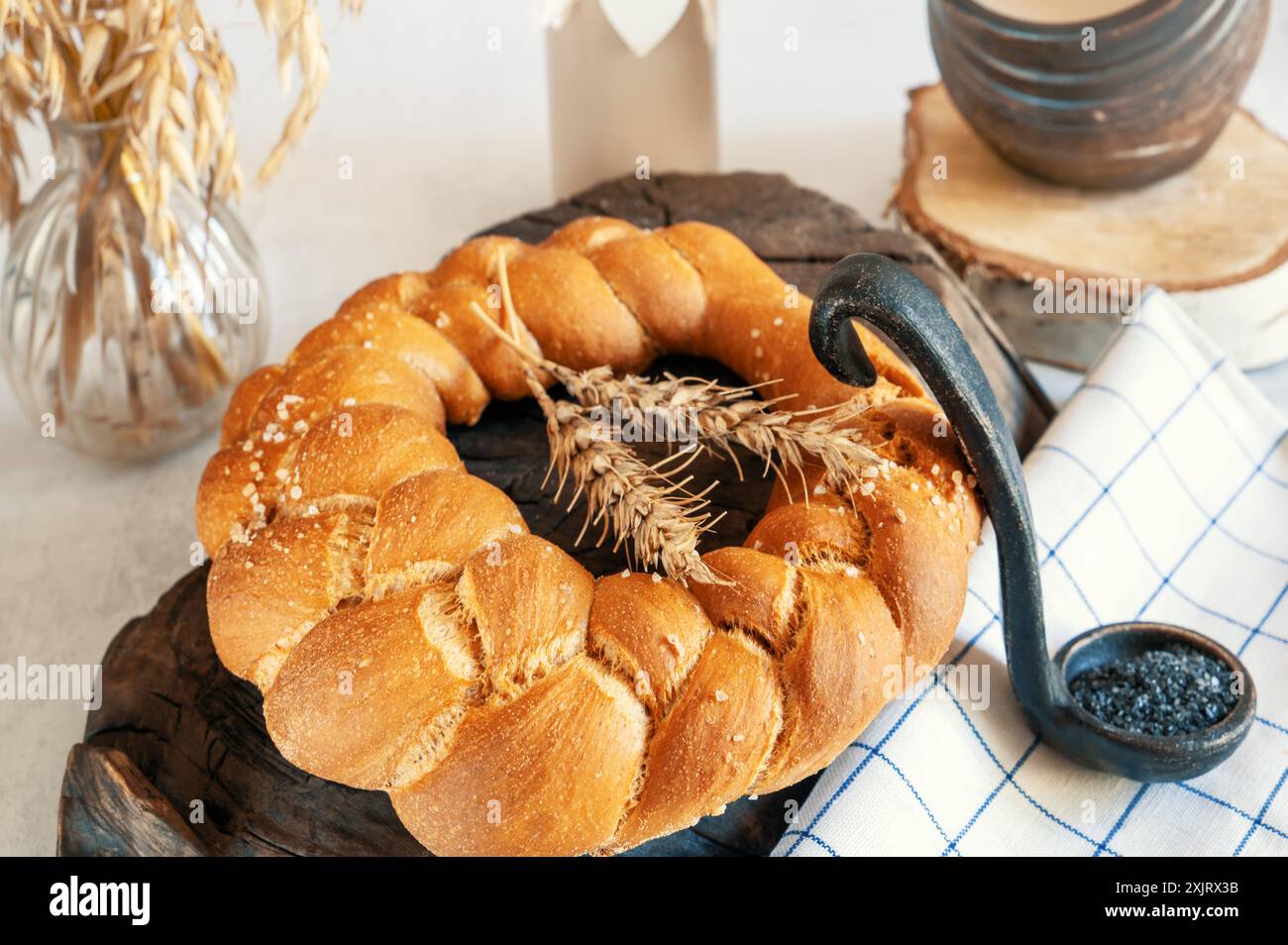 Pain tressé, challah, pain aromatique frais au sel noir. Pain au levain au blé maison. Une miche ronde de pain fraîchement cuit. Banque D'Images