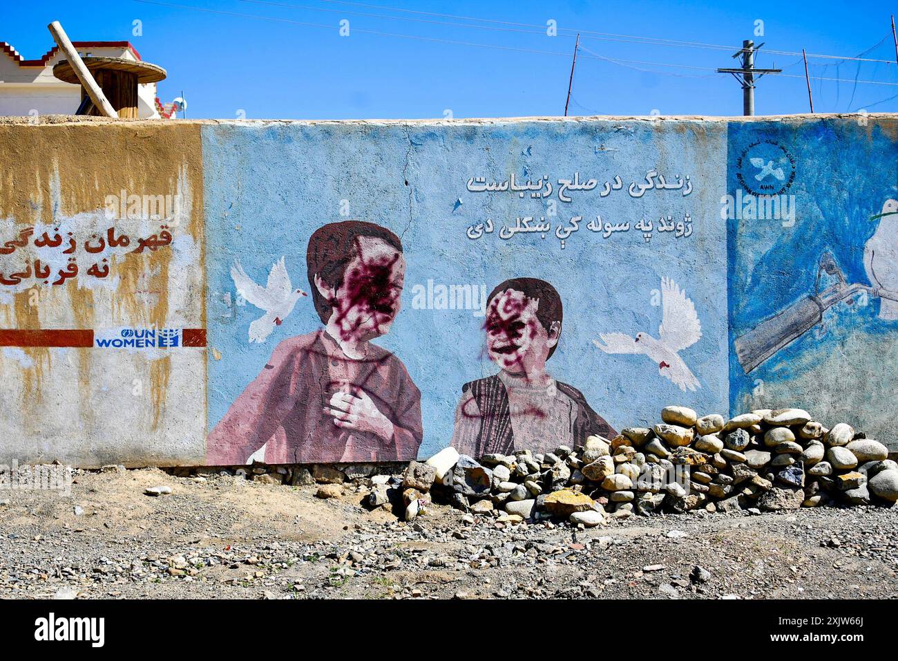 Une fresque murale de rue dégradée en Afghanistan représentant des enfants avec leurs visages peints, reflétant les actions oppressives des talibans. Banque D'Images