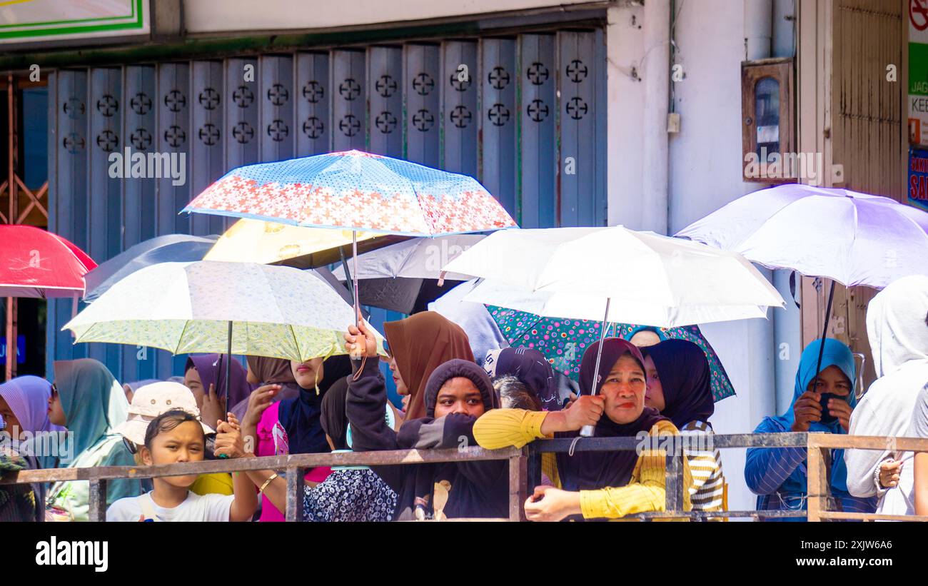 Des foules de gens utilisent des parapluies pour se protéger du soleil chaud Banque D'Images