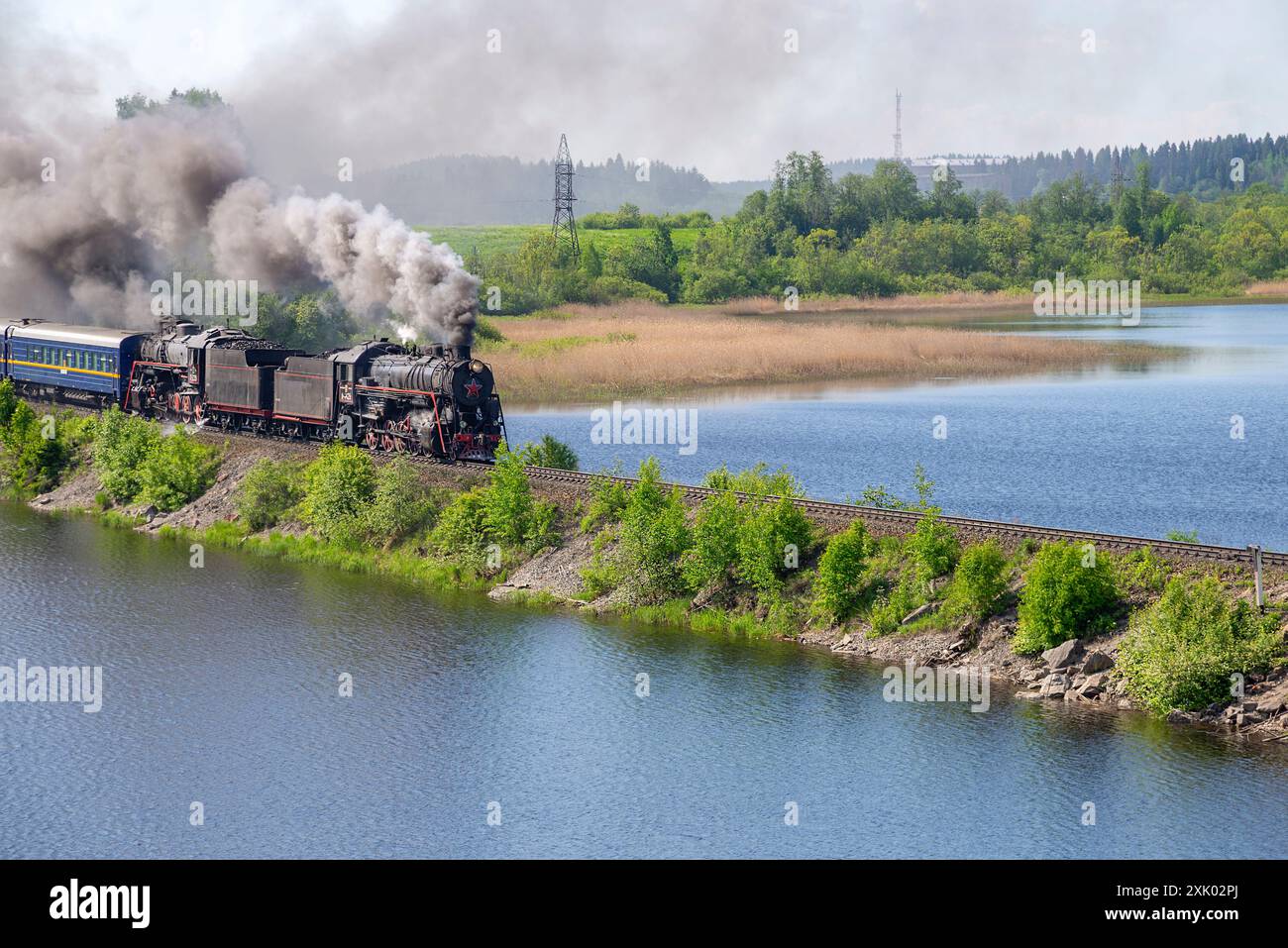 CARÉLIE, RUSSIE - 11 JUIN 2022 : une vieille locomotive à vapeur à deux sections avec un train touristique pénètre dans le barrage. Carélie, Russie Banque D'Images