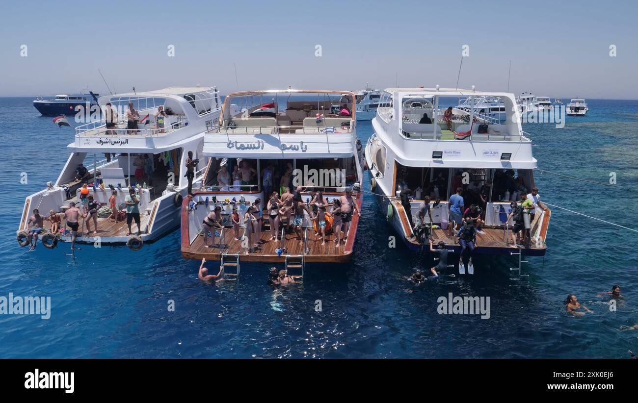 Les touristes explorent le récif corallien lors d'une excursion de plongée en apnée au récif de Gota Abu Ramada, en mer Rouge, lors d'une excursion d'une journée au départ de la marina d'Hurghada, en Égypte. Banque D'Images