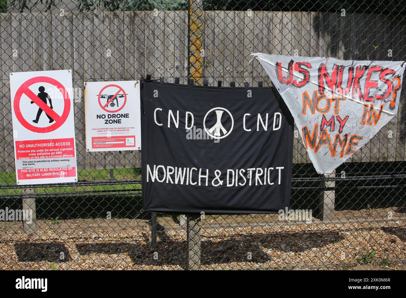 Lakenheath, Angleterre, Royaume-Uni. 20 juillet 2024. Les manifestants laissent des banderoles à côté des panneaux de sécurité devant la base aérienne de Lakenheath, pendant la manifestation. La manifestation a été organisée par la campagne pour le désarmement nucléaire (CND), dont les partisans s'opposent au retour potentiel des armes nucléaires dans les bases militaires au Royaume-Uni, telles que la RAF Lakenheath après qu'il a été signalé que les États-Unis ont l'intention de résister aux bombes nucléaires sur la base. Après une protestation soutenue, les armes nucléaires ont été retirées de Lakenheath en 2008. (Crédit image : © Martin Pope/ZUMA Press Wire) USAGE ÉDITORIAL SEULEMENT! Non destiné à UN USAGE commercial ! Banque D'Images