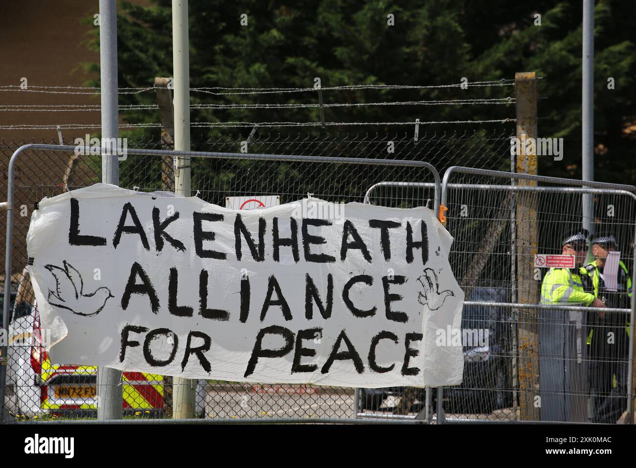 20 juillet 2024, Lakenheath, Angleterre, Royaume-Uni : les manifestants laissent une pancarte disant ''˜Alliance pour la paix de Lakenheath' attachée à l'escrime devant la base aérienne de Lakenheath, pendant la manifestation. La manifestation a été organisée par la campagne pour le désarmement nucléaire (CND), dont les partisans s'opposent au retour potentiel des armes nucléaires dans les bases militaires au Royaume-Uni, telles que la RAF Lakenheath après qu'il a été signalé que les États-Unis ont l'intention de résister aux bombes nucléaires sur la base. Après une protestation soutenue, les armes nucléaires ont été retirées de Lakenheath en 2008. (Crédit image : © Martin Pope/ZUMA Press Wire) EDITORIAL Banque D'Images