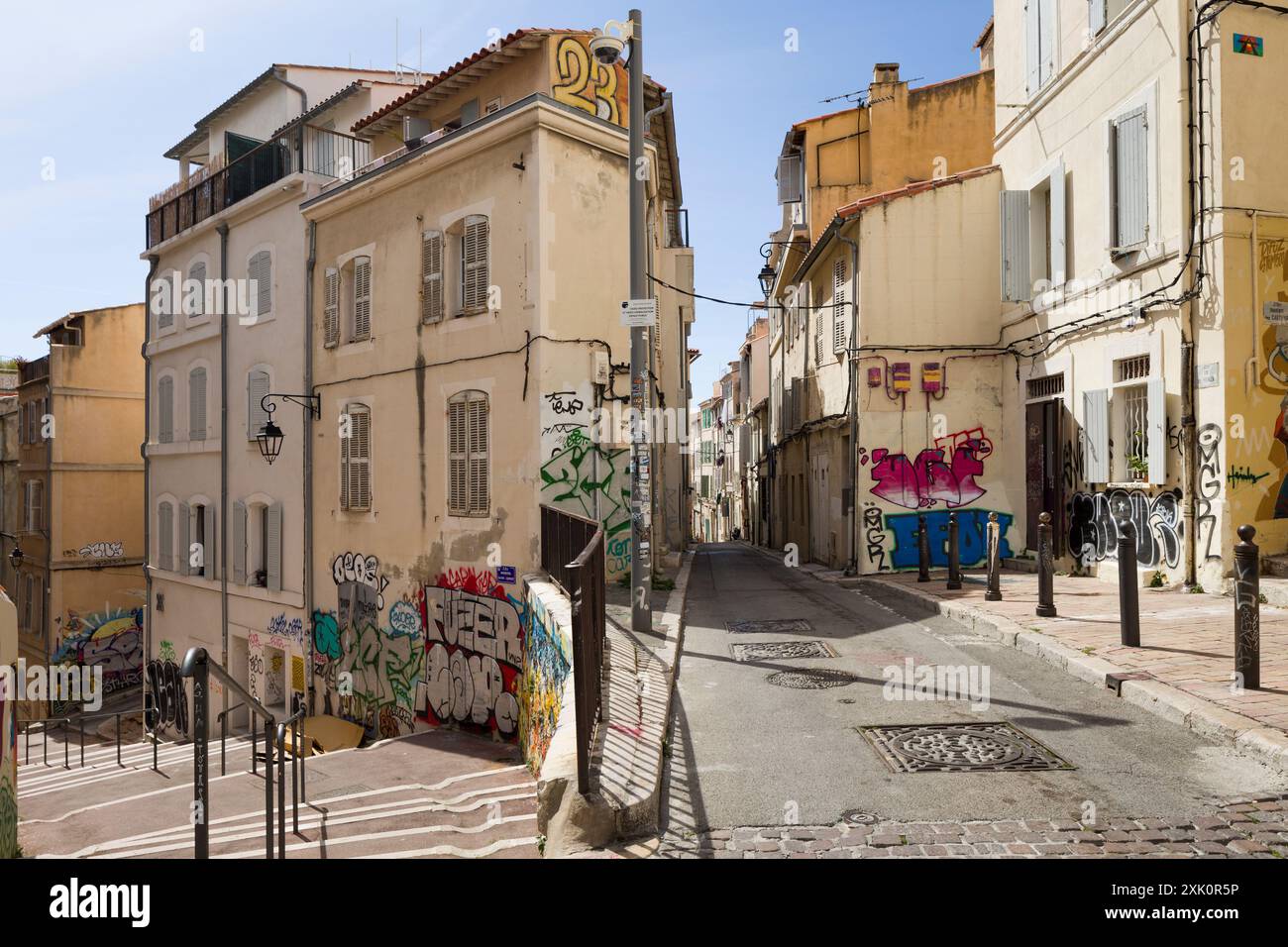 Rue typique, rue du Poirier, dans le quartier le panier, Marseille, France, jonction de ruelles étroites avec marches, bâtiments couverts de graffitis. Banque D'Images