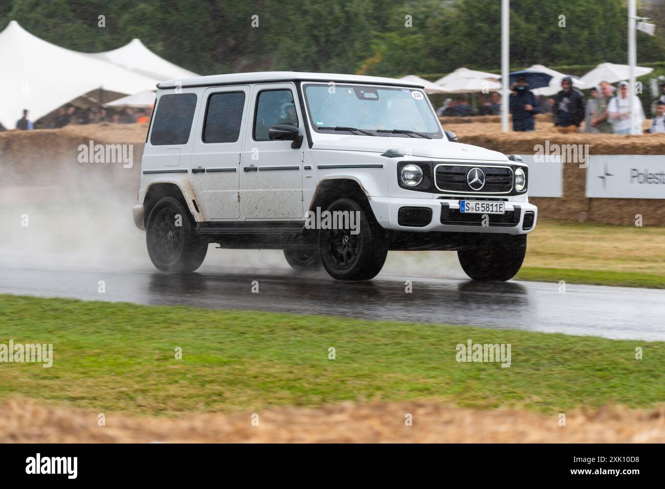 Mercedes-Benz G 580 2024 avec technologie EQ gravissant la piste de montée sous de fortes pluies lors du Goodwood Festival of Speed 2024 Motorsport Event, Royaume-Uni Banque D'Images