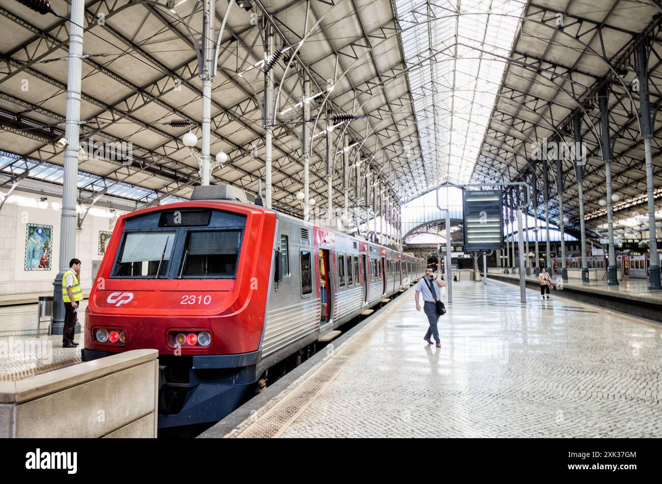 Gare de Rossio quai Lisbonne Portugal // LISBONNE, Portugal — Un train à destination de Sintra attend au quai de la gare de Rossio à Lisbonne. La gare néo-manuéline, construite à la fin du XIXe siècle, sert de plaque tournante de transport reliant la capitale portugaise aux régions environnantes. La ligne Sintra est l'une des routes de banlieue les plus populaires, reliant Lisbonne à la ville classée au patrimoine mondial de l'UNESCO connue pour ses palais et ses jardins. La gare de Rossio, officiellement connue sous le nom de Estação do Rossio, présente des arcs en fer à cheval distinctifs et une façade ornée caractéristique de l'arc de renouveau portugais Banque D'Images