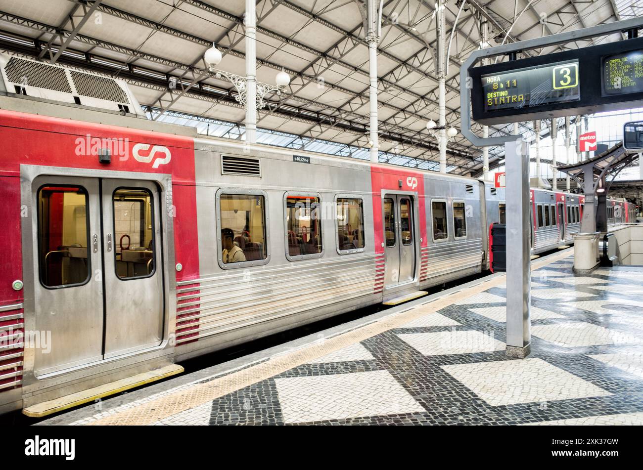 Train de la gare Rossio pour Sintra Lisbonne Portugal // LISBONNE, Portugal — Un train à destination de Sintra attend au quai de la gare Rossio de Lisbonne. La gare néo-manuéline, construite à la fin du XIXe siècle, sert de plaque tournante de transport reliant la capitale portugaise aux régions environnantes. La ligne Sintra est l'une des routes de banlieue les plus populaires, reliant Lisbonne à la ville classée au patrimoine mondial de l'UNESCO connue pour ses palais et ses jardins. La gare de Rossio, officiellement connue sous le nom de Estação do Rossio, présente des arcs en fer à cheval distinctifs et des façades ornées caractéristiques de la renaissance portugaise Ar Banque D'Images