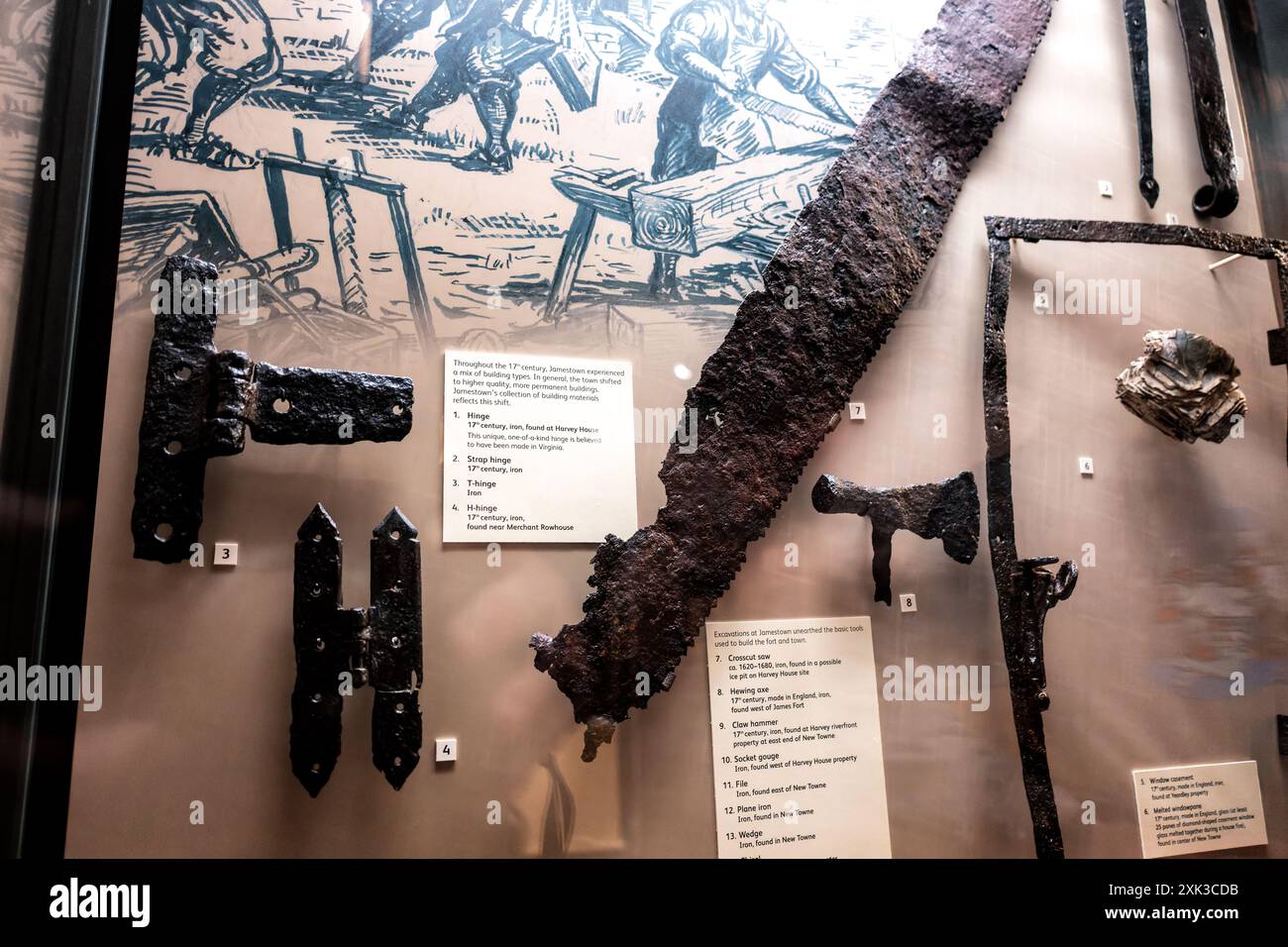Jamestown Museum 17th Century Building Tools Virginia // JAMESTOWN, Virginie — des outils et du matériel de construction du 17e siècle sont exposés au musée de Jamestown, récupérés par des fouilles archéologiques sur le site de la première colonie anglaise permanente d'Amérique. Les artefacts comprennent des charnières, des scies, des haches, des marteaux et d'autres instruments de construction qui illustrent l'évolution des structures temporaires vers des bâtiments plus permanents tout au long des années 1600 De nombreux outils ont été fabriqués en Angleterre et importés dans la colonie, tandis que certains éléments comme une charnière unique ont été trouvés à Harvey House A. Banque D'Images