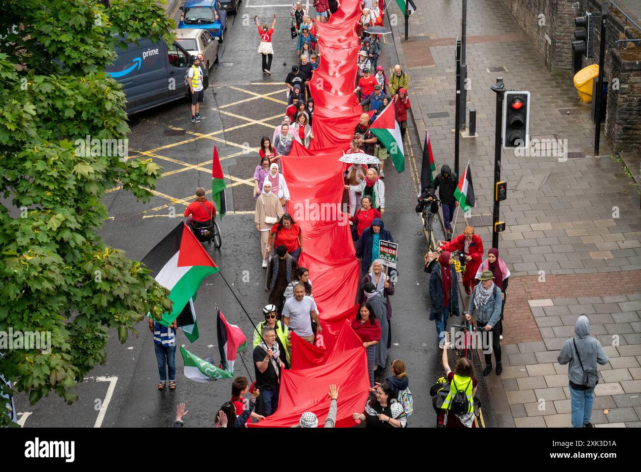 Bristol, Royaume-Uni. 20 juillet 2024. Des centaines de personnes ont transporté un quart de kilomètre de tissu rouge dans les rues du centre de Bristol, pour souligner la guerre contre les habitants de Gaza qui en est maintenant à son neuvième mois. Crédit : Natasha Quarmby/Alamy Live News Banque D'Images