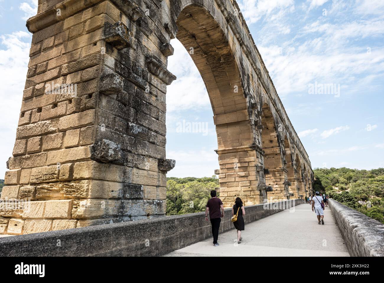 VERS-PONT-DU-GARD, France — le majestueux Pont du Gard, un ancien aqueduc romain classé au patrimoine mondial de l'UNESCO, enjambe le paisible Gardon dans le sud de la France. Ce remarquable pont à trois niveaux met en valeur l'ingéniosité de l'ingénierie romaine dans le paysage méditerranéen pittoresque. Banque D'Images