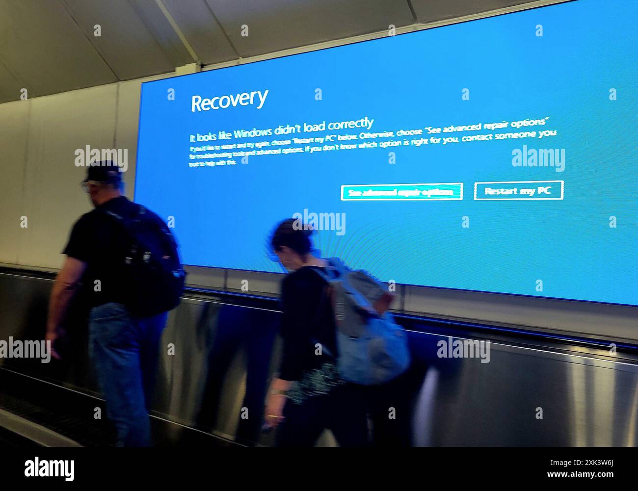 Washington, États-Unis. 20 juillet 2024. Des voyageurs passent devant un écran affichant un message d'erreur Microsoft Windows à l'aéroport international de Dulles à Washington, DC, le samedi 20 juillet 2024. Le chaos de la panne technologique mondiale de vendredi est entré dans un deuxième jour dans les aéroports à travers les États-Unis avec plus de 8 000 vols annulés ou retardés. Photo de Pat Benic/UPI crédit : UPI/Alamy Live News Banque D'Images