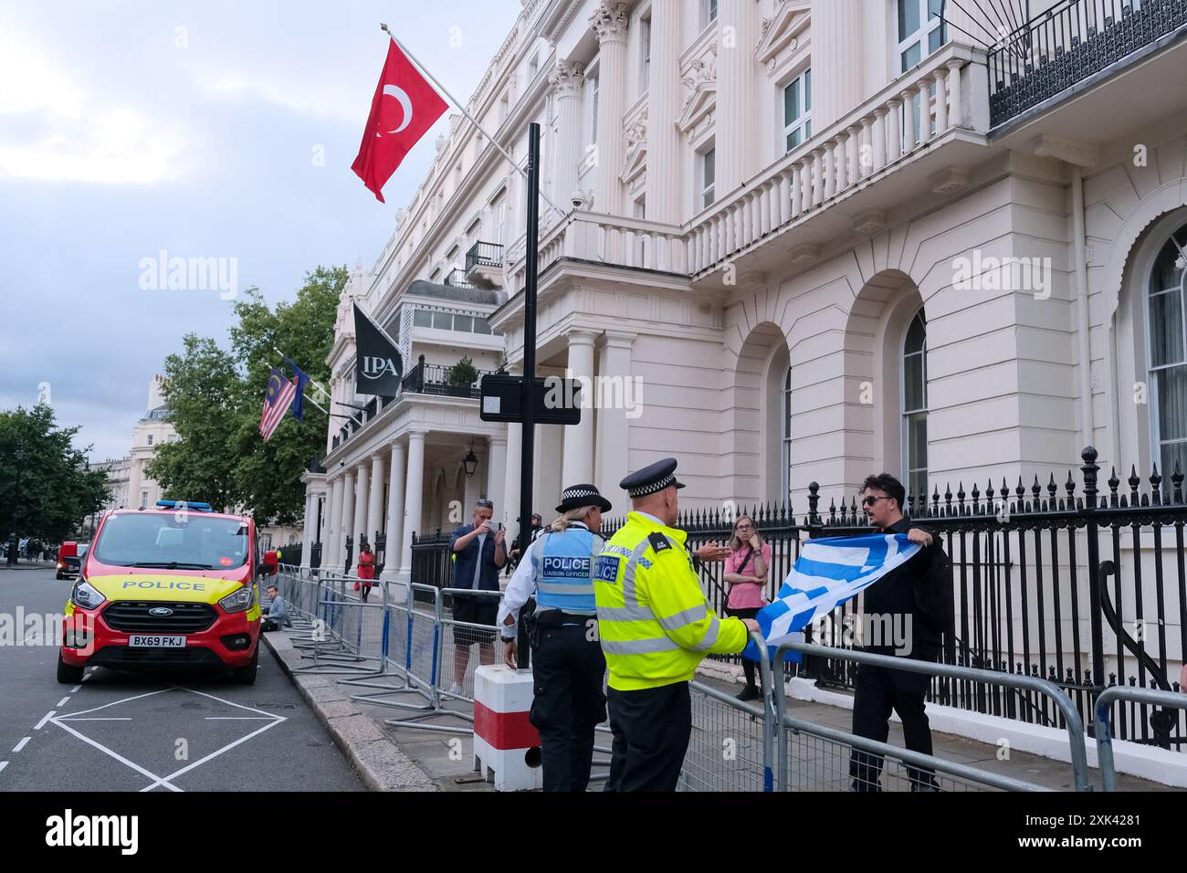 Londres, Royaume-Uni, 20 juillet 2024. Un homme agite un drapeau grec en passant devant l'ambassade turque. La Fédération nationale des Chypriotes a protesté à l'occasion du 50e anniversaire de l'invasion turque, appelant à la réunification et à la sortie des troupes de la partie nord de l'île tbe capturée en 1974 après une tentative de coup d'État par le gouvernement militaire grec. Crédit : onzième heure photographie/Alamy Live News Banque D'Images
