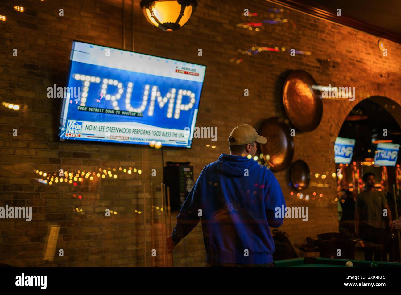 Milwaukee, États-Unis. 18 juillet 2024. Une personne jouant au billard dans un bar près de Fiserv Forum regarde le président Donald J. Trump monter sur scène le dernier jour de la Convention nationale républicaine (RNC), à Milwaukee, Wisconsin. La convention s'est déroulée comme prévu malgré la tentative d'assassinat contre Trump et s'est conclue par l'acceptation de la nomination présidentielle de son parti. (Photo de Jeremy Hogan/SOPA images/Sipa USA) crédit : Sipa USA/Alamy Live News Banque D'Images