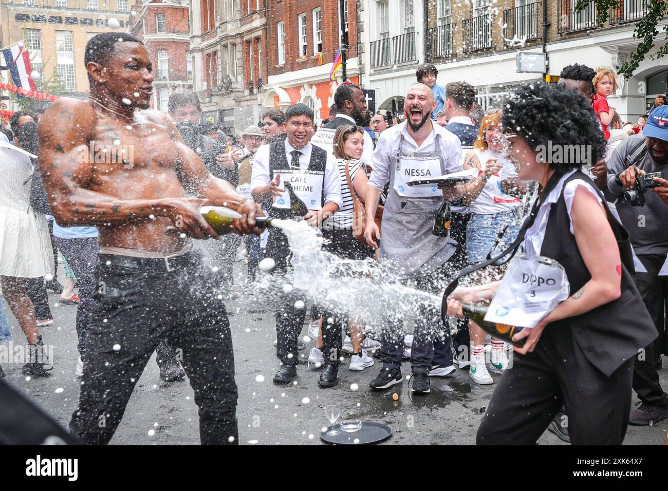 Londres, 21 juillet 2024. Les participants de la 'Daisy Green' célèbrent avec des bouteilles de pétillant. Des dizaines de participants à la course des serveurs de Soho courent le long d'un itinéraire fixe à Soho avec un plateau, des verres et du champagne, puis célèbrent la course et célèbrent dans les rues de Soho. L'événement traditionnel amusant voit le personnel de service de nombreux bars, pubs et restaurants de la région concourir chaque année. Crédit : Imageplotter/Alamy Live News Banque D'Images