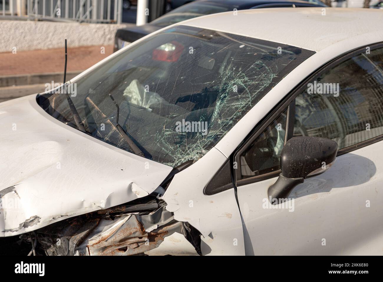 Gros plan de la voiture montrant des dommages importants à l'avant après une collision, mettant en évidence le pare-brise brisé et le capot déformé. Parfait pour le contenu sur la route Banque D'Images