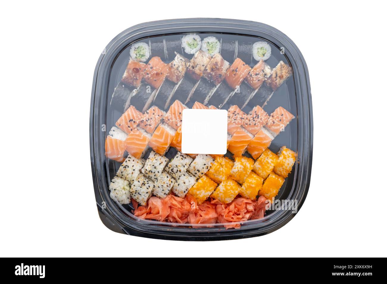 Boîte en plastique avec un ensemble de sushis et une étiquette vierge sur le dessus pour le logo ou le texte de l'entreprise, vue de dessus de table isolée Banque D'Images
