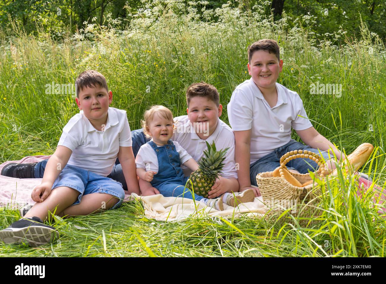 Grande famille sympathique dans la nature. Quatre frères. Tous les enfants sont rassasiés, heureux, le plus petit a un an Banque D'Images