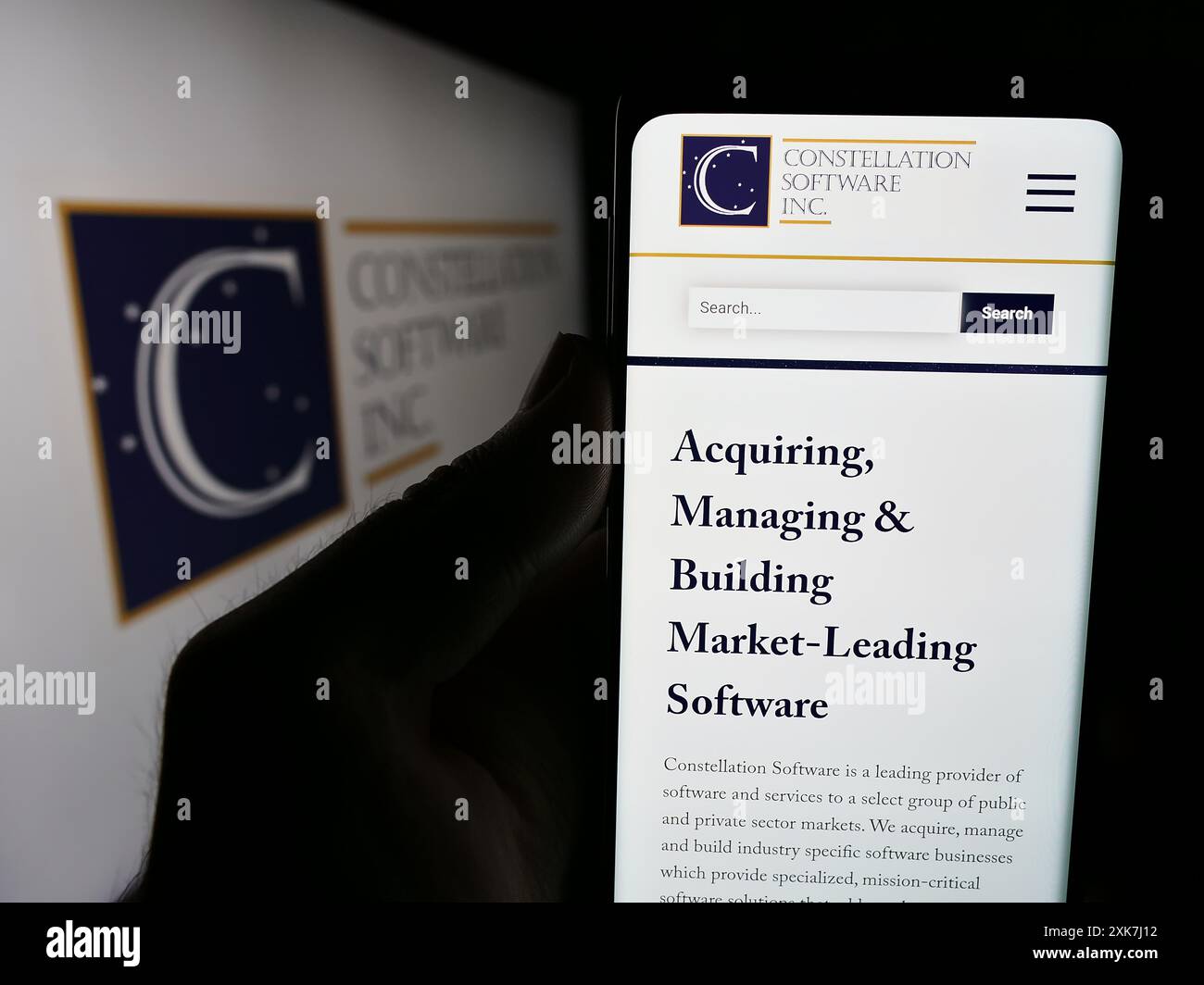 Personne tenant un téléphone intelligent avec le logo de la société canadienne Constellation Software Inc devant le site Web. Concentrez-vous sur l'affichage du téléphone. Banque D'Images