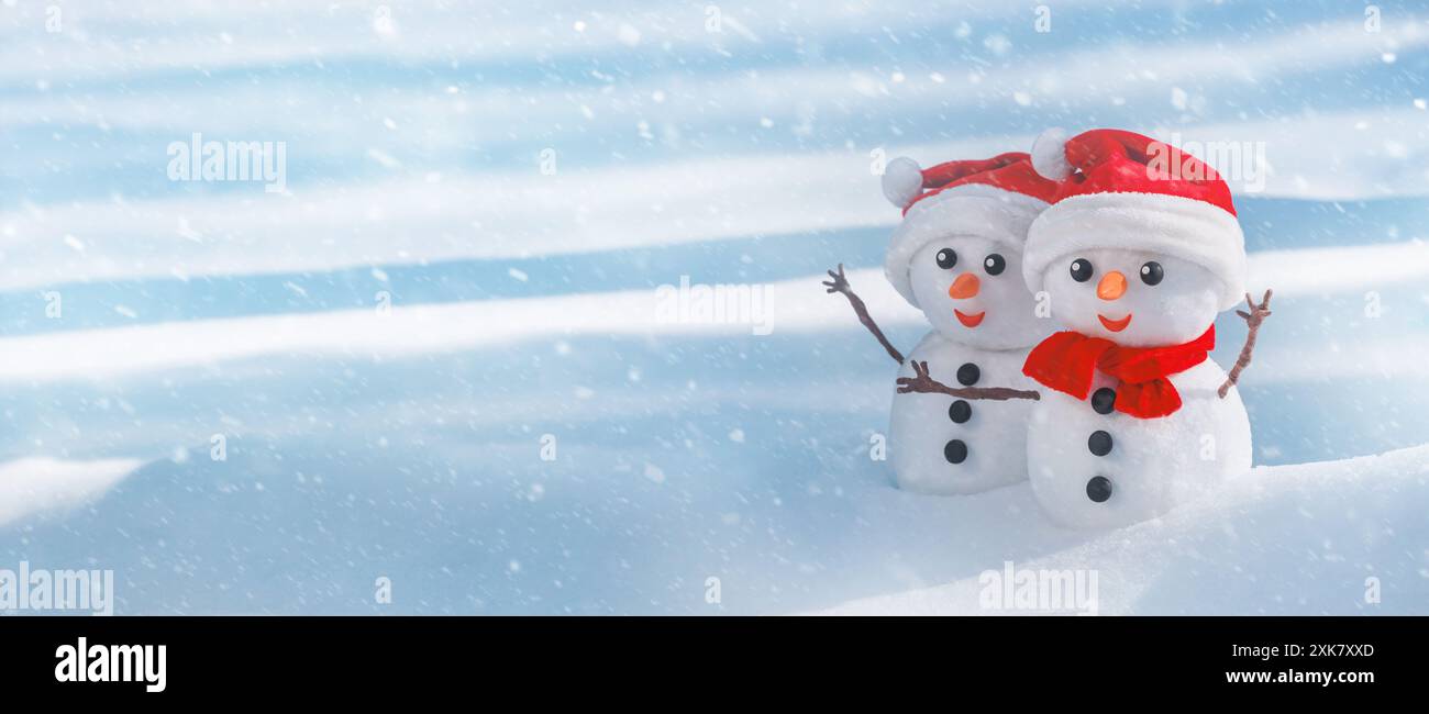 Bannière d'hiver de Noël avec couple de bonhommes de neige dans un chapeau de père noël sur leurs têtes dans une forêt d'hiver. Fond de vacances avec espace de copie pour le texte Banque D'Images
