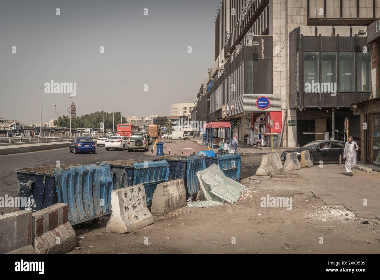 Les barrages routiers en béton et les conteneurs à ordures dans la rue du centre-ville de Djeddah pendant la chaude journée d'hiver en Arabie Saoudite. Banque D'Images