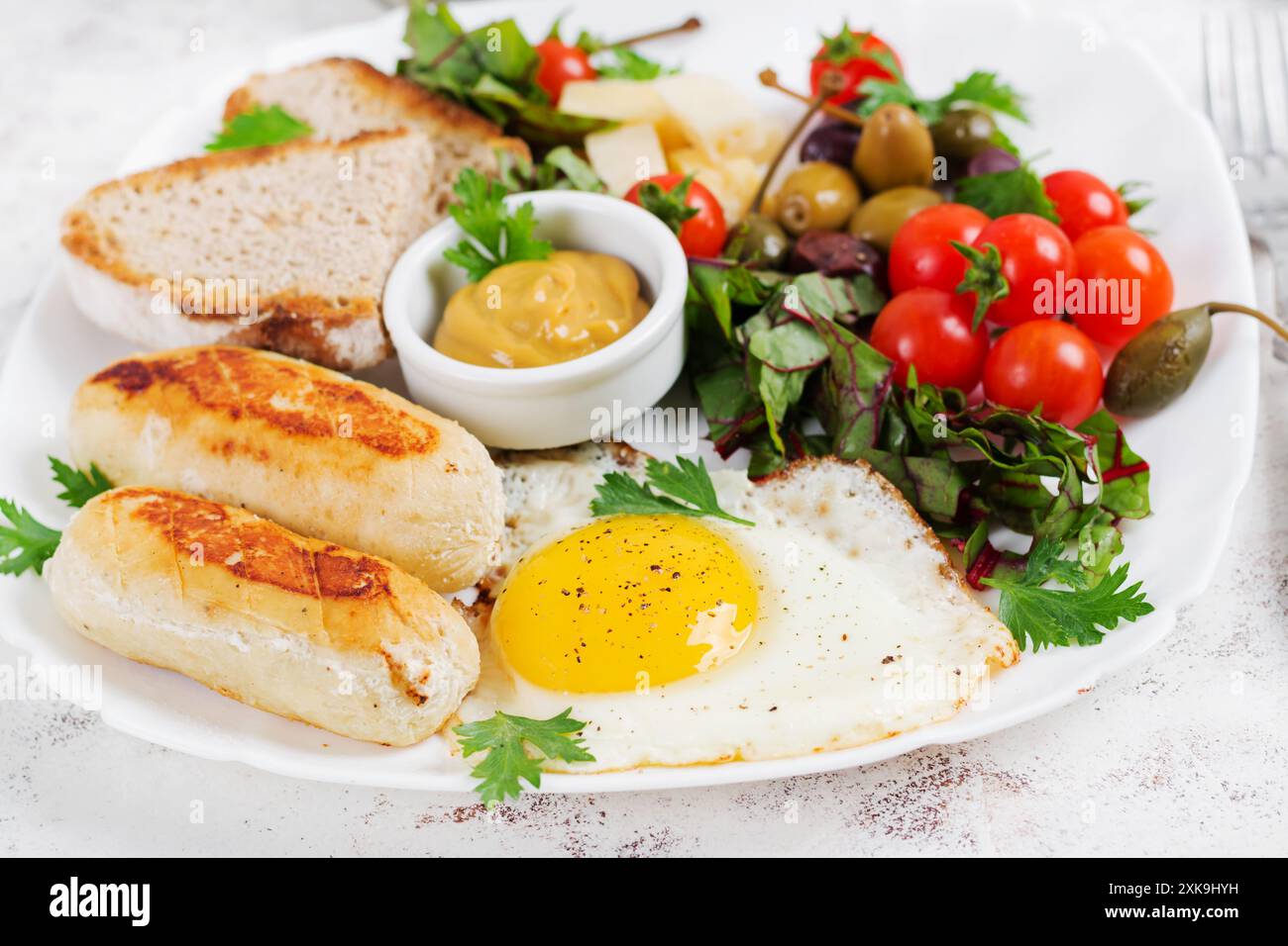 Oeuf frit, saucisse de poulet maison, toasts et salade fraîche. Keto, petit déjeuner paléo. Banque D'Images