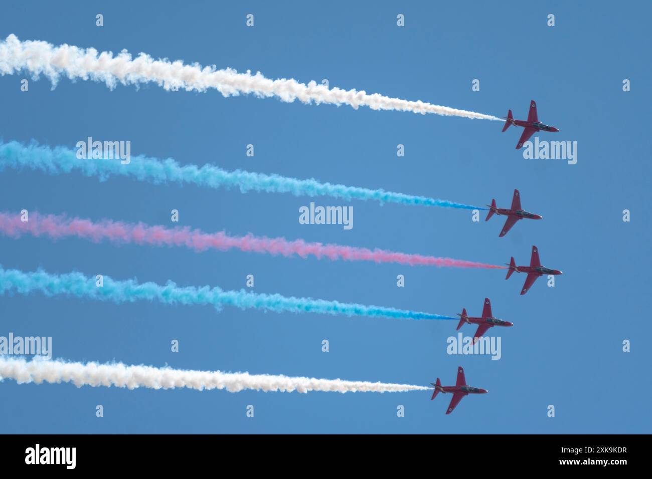 Cinq des flèches rouges volent en formation avec de la fumée rouge, blanche et bleue survolent le Grand Prix de Silverstone en 2024. Banque D'Images