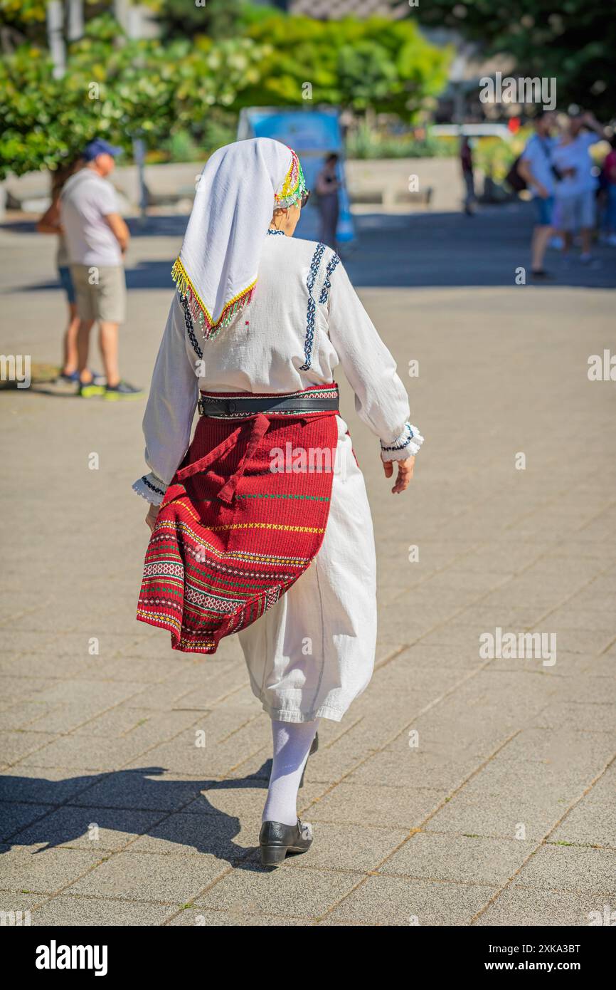 Femme en vêtements bulgares traditionnels marchant dans la rue Sunny City. Mode de vie actif des personnes âgées Banque D'Images