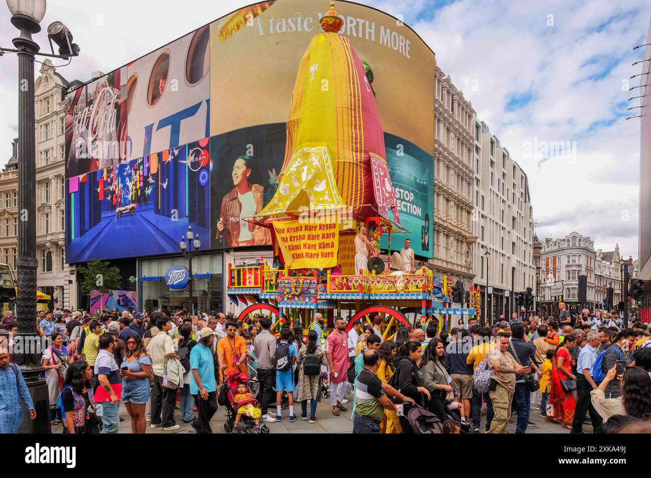 21 juillet 2024, Londres Royaume-Uni. Les adeptes de la religion Hare Krishna assistent à la parade Rathayatra londonienne alors que trois grands chars colorés sont tirés à la main dans les rues du centre de Londres. Sur la photo : les chars passent par Piccadilly Circus sur la route de la procession. Banque D'Images