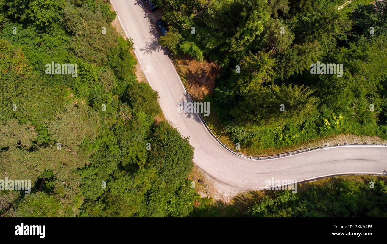 Lago di Ledro, Italie - 21 juillet 2024 : une route sinueuse serpente à travers une forêt dense près de Lago di Ledro en Italie. Vue aérienne *** Eine kurvige Straße windet sich durch einen dichten Wald nahe dem Lago di Ledro in Italien. Luftaufnahme Banque D'Images
