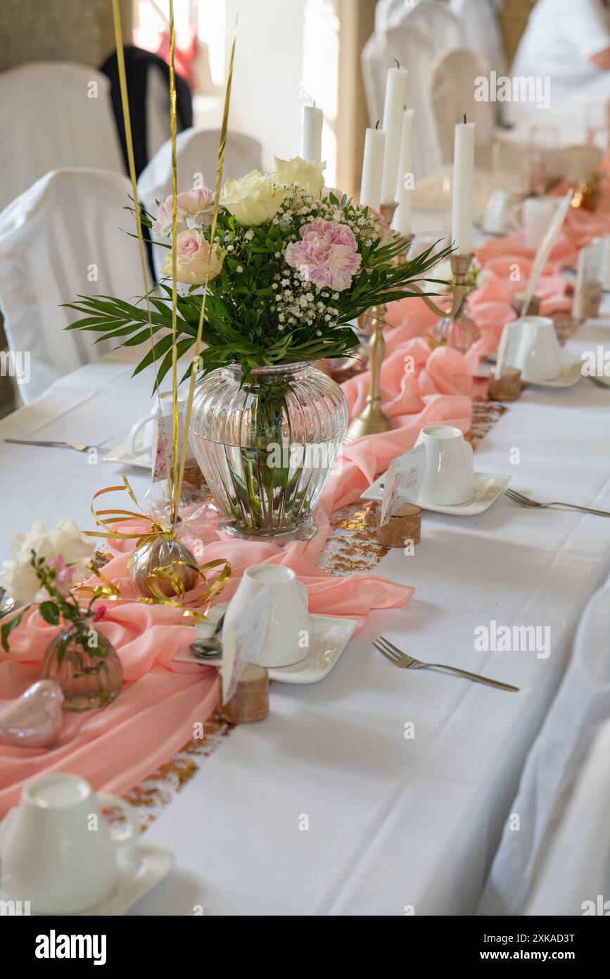 décorations de mariage. Nous avons mis la table de mariage avec des fleurs fraîches décoratives, les détails de la fête. arrangement floral, assiettes et bougies dans une bougie Banque D'Images